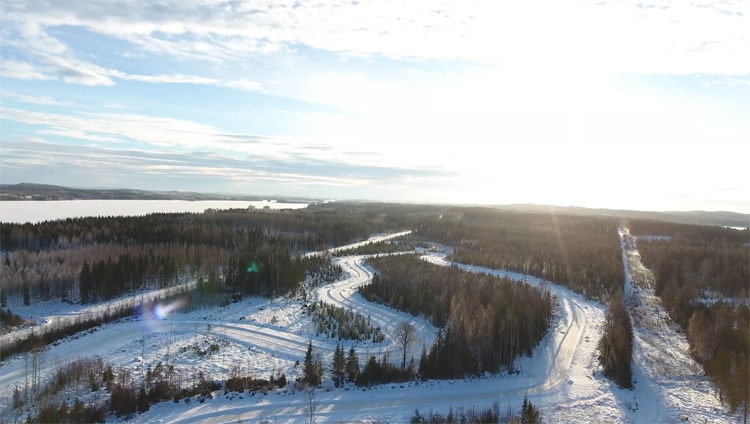 Auto's rijden over ijsbaan en worden gefilmd met drone